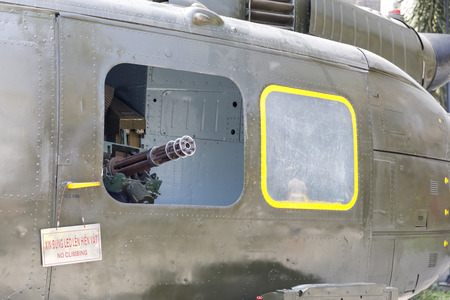 SAIGON, VIETNAM - FEBRUARY 23, 2018: Machine gun on a window of US Army helicopter in a war museum...