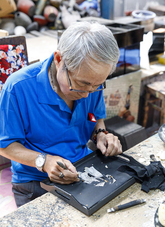 SAIGON, VIETNAM - FEBRUARY 23, 2018: Worker creates a painting at a factory in Saigon, Vietnamのeditorial素材
