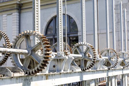 Heavy white gear wheels of machinery to open water gates at river Rhone in Geneva, Switzerland