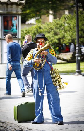 TALLINN, ESTONIA - JULY 05, 2019: Clown plays music instruments on a street in Tallinn, Estonia on July 05, 2019のeditorial素材