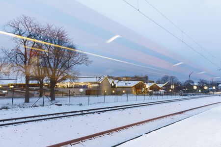 TALLINN, ESTONIA - DECEMBER 23, 2018: Rails and light strips of passing trains on snowy winter evening in Tallinn, Estonia on December 23, 2018のeditorial素材