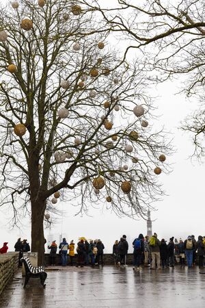 TALLINN, ESTONIA - DECEMBER 22, 2019: Decorated tree and tourists at viewpoint in the old town of Tallinn, Estonia in December 2019のeditorial素材