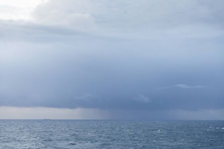 Dark storm clouds full of rain above the seaの写真素材