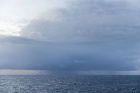 Dark storm clouds full of rain above the seaの写真素材