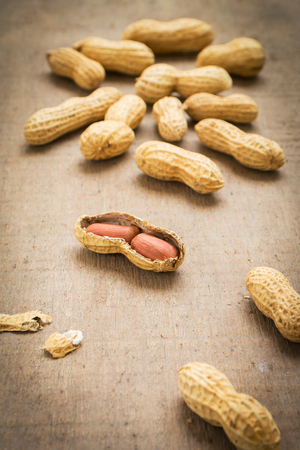 Peanuts with shells on a wooden tableの写真素材
