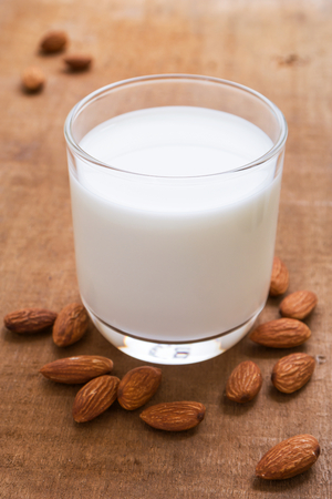 Almond milk and almond on wooden tableの写真素材
