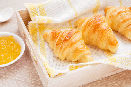Croissants on wooden tray and fruit  jamの写真素材