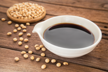 Soy sauce and soy bean on wooden backgroundの写真素材