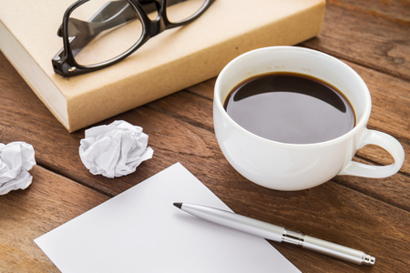 Coffee cup and book on wooden tableの写真素材