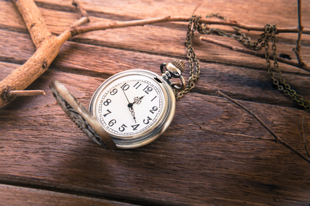 Pocket watch on wooden background, vintage style lightの写真素材