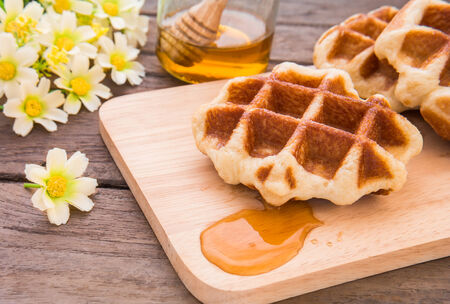 Waffles with honey on wooden plateの写真素材