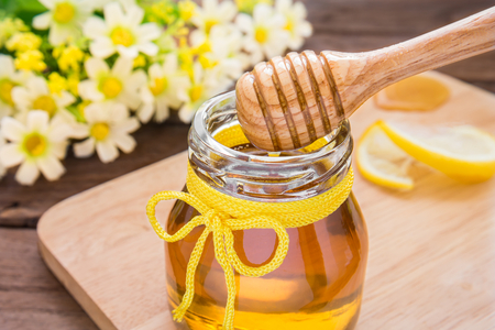 Honey dipper in glass jarの写真素材