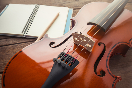 Close up of violin and book on wooden tableの写真素材