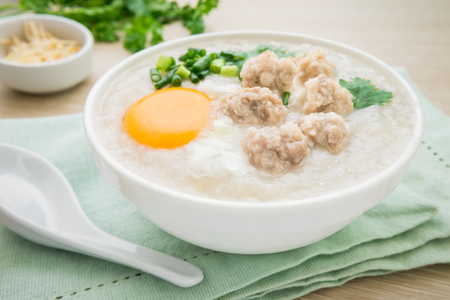Congee with minced pork and boiled egg in bowlの写真素材