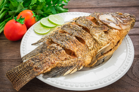 Fried fish on plate with vegetablesの写真素材