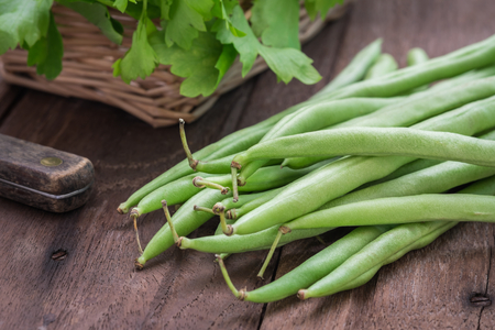 Green beans on wooden tableの写真素材