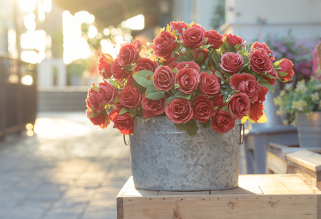 Bouquet of red roses in bucket on wooden crate, filtered imageの写真素材