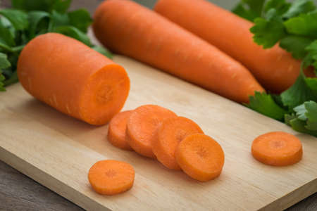 Carrots slices on wooden cutting boardの写真素材
