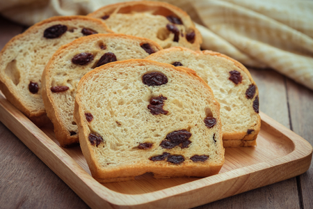 Sliced raisin bread on wooden plateの写真素材