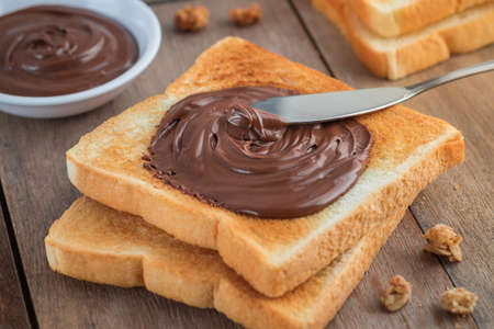 Bread with chocolate cream on wooden tableの写真素材