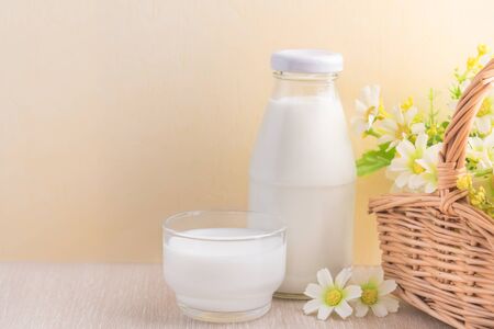 Glass of milk and milk bottle on tableの写真素材