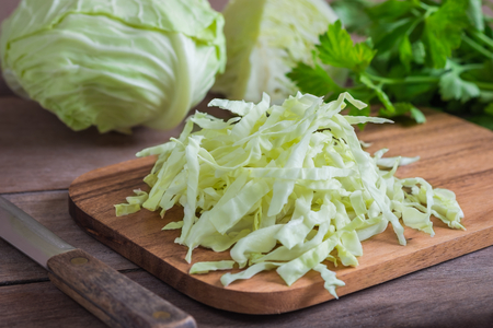 Fresh shredded cabbage on wooden cutting boardの写真素材