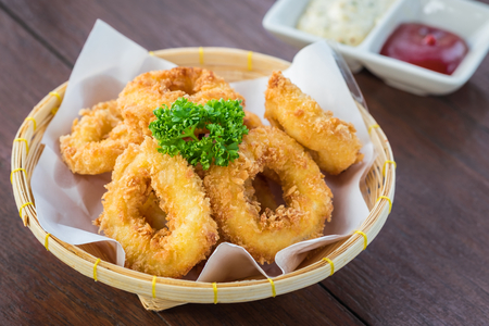 Fried calamari rings in wicker basket and sauceの写真素材