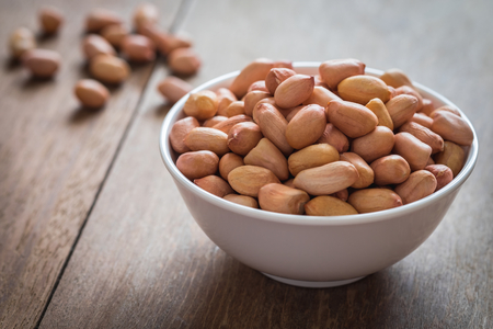 Raw peanuts in white bowlの写真素材