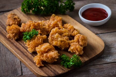 Crispy popcorn chicken on wooden board and dipping sauceの写真素材