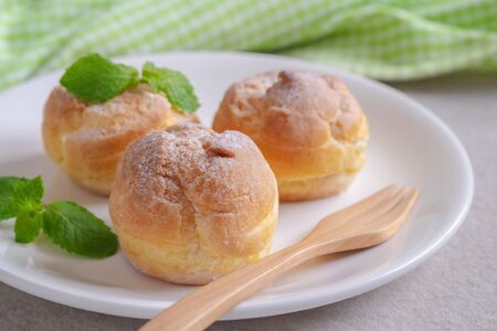 Cream puffs on white plateの写真素材