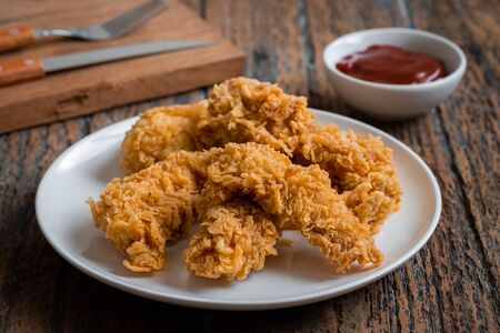 Crispy fried breaded chicken strips on plate and ketchupの写真素材