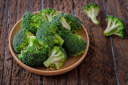 Fresh green broccoli on wooden plateの写真素材