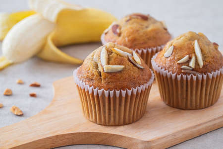 Banana muffins with almond on wooden boardの写真素材