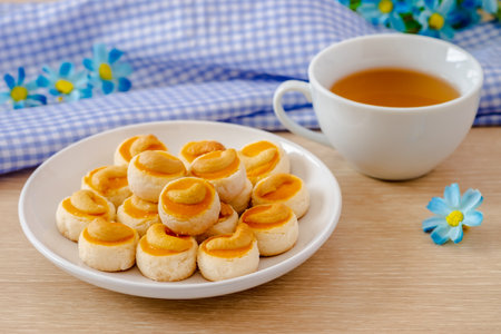 Cashew nut cookies or Singapore cookies on white plate and cup of teaの写真素材
