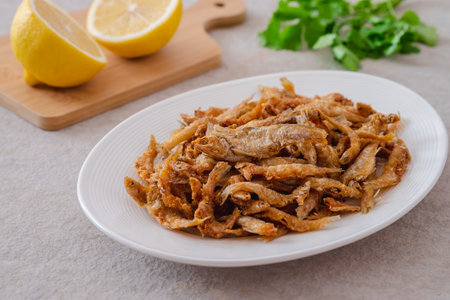 Crispy fried small fish on white plateの写真素材
