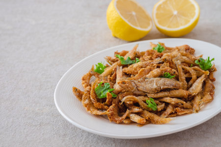 Crispy fried small fish on white plateの写真素材