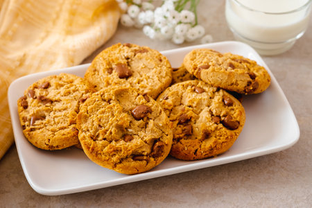 Chocolate chip cookies on white plate and glass of milkの写真素材