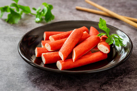 Fresh crab sticks on black plateの写真素材