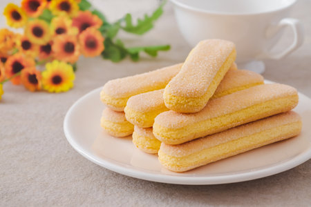 Lady finger biscuits, Italian dessert and sponge cookie on white plate and coffee cupの写真素材