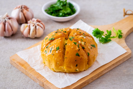 Korean cream cheese garlic bread on wooden board and raw garlic clovesの写真素材