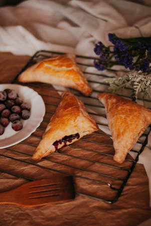 Freshly baked croissants with berries on a wooden table.