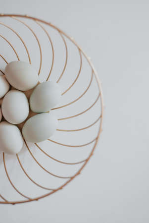 White eggs in a basket on a white background. Easter concept.の写真素材