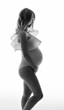 Pregnant girl in white underwear on a light backgroundの写真素材