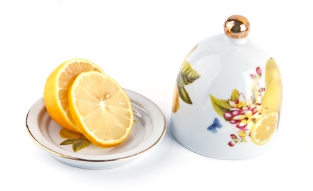 sliced lemon on plate with a cover isolatedの写真素材