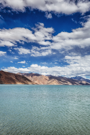 Mountains and Pangong tso (Lake). It is huge lake in Ladakh, with snow peaks and blue sky in background, it extends from India to Tibet. Leh, Ladakh, Jammu and Kashmir, Indiaの写真素材
