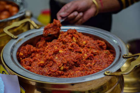 Gajar ka halwa is a carrot-based sweet dessert pudding from India. Garnished with Cashew/almond nuts and Served in a bowl over colourful/wood backgroundの写真素材