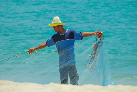 PRACHAUPKHIRIKHAN,THAILAND- APRIL 15: Fisherman storage nets on the beach after leaving the night to...