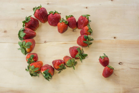 Fresh strawberries heart on old wooden backgroundの写真素材