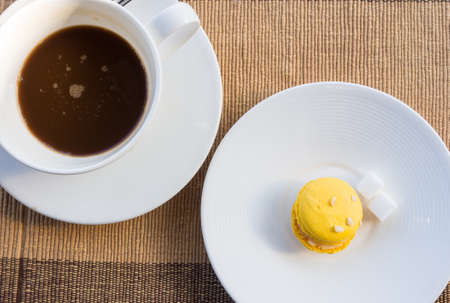 More colorful macarons and hot coffee in cup on fabric backgroundの写真素材