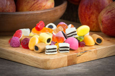 Mix jelly fruits  on apple and wooden backgroundの写真素材